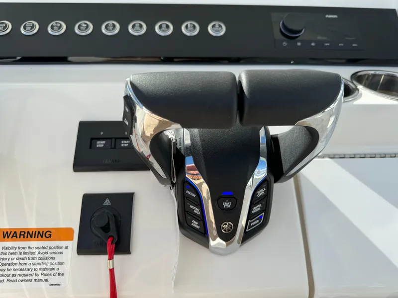 Slide: The Image of 2024 Regulator 23 boat throttle controls with warning label and dashboard. - 30