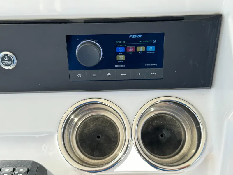 Slide: The Image of Fusion audio system on 2024 Regulator 23 boat dashboard with dual cup holders. - 31