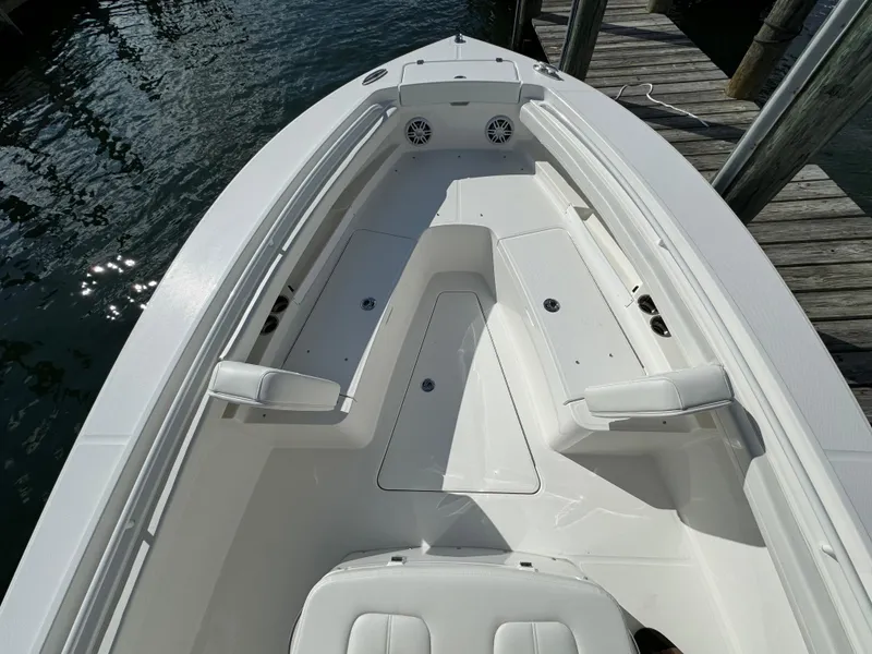 Slide: The Image of 2024 Regulator 23 boat interior with seating and storage, docked by the water. - 36