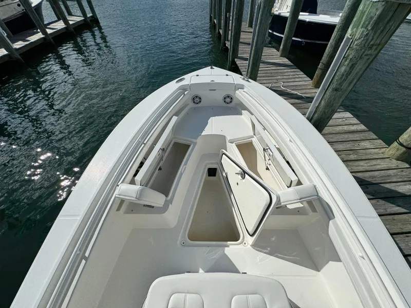 Slide: The Image of 2024 Regulator 23 boat docked, showcasing spacious bow seating and storage compartments. - 37