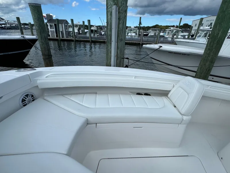 Slide: The Image of 2024 Regulator 23 boat interior with white seating at a marina. - 40