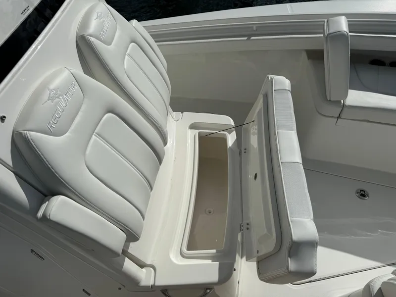 Slide: The Image of 2024 Regulator 23 boat with open storage compartment and cushioned seating. - 47