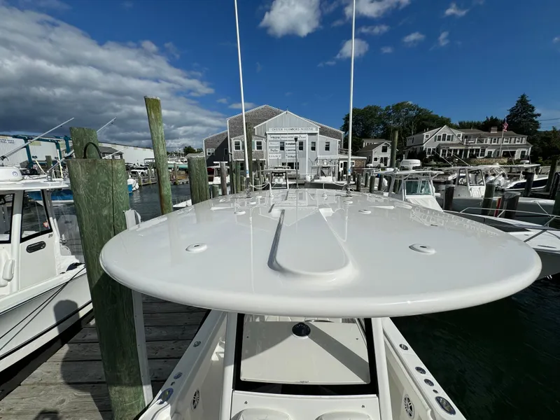 Slide: The Image of 2024 Regulator 23 boat docked at marina under blue sky. - 49