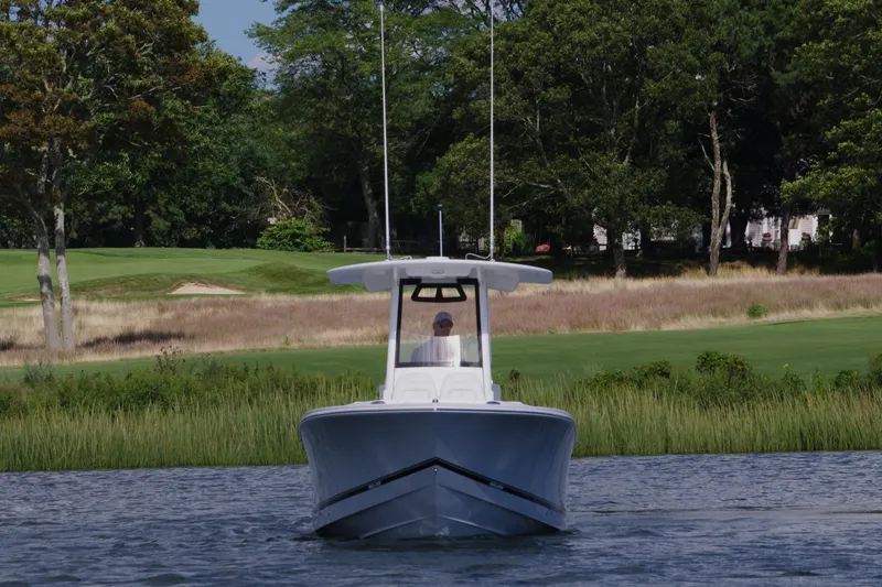 Slide: The Image of 2024 Regulator 23 boat on calm water with lush green background. - 8