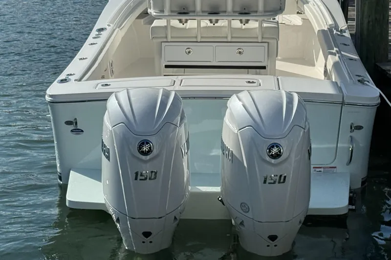 Slide: The Image of 2024 Regulator 23 boat with dual Yamaha 150 outboard engines on water. - 11