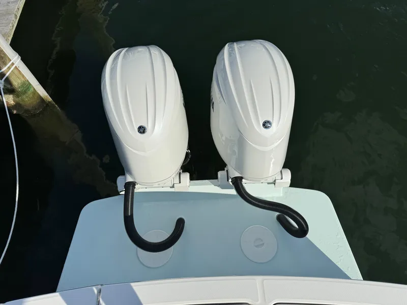 Slide: The Image of 2024 Regulator 23 boat with dual outboard engines, docked on calm water. - 12