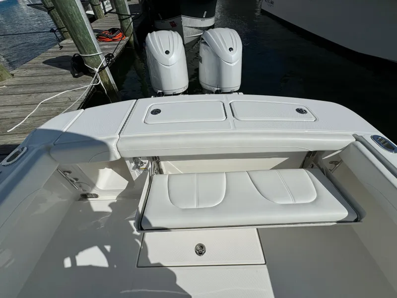 Slide: The Image of 2024 Regulator 23 boat with dual engines and white seating at dock. - 16