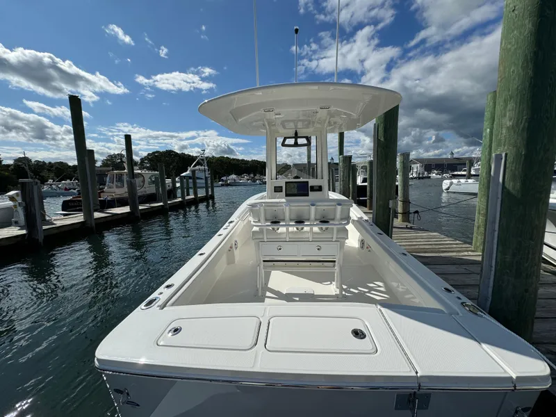 Slide: The Image of 2024 Regulator 23 boat docked at marina under blue sky. - 21