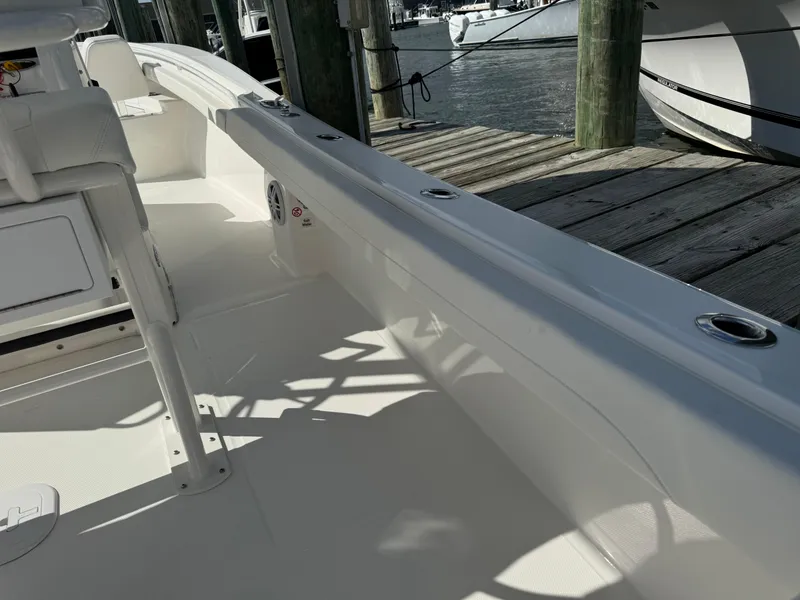 Slide: The Image of 2024 Regulator 23 boat interior, docked at marina, showcasing sleek design and spacious deck. - 23