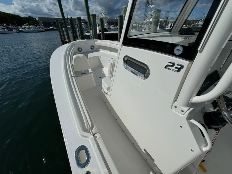 Slide: The Image of 2024 Regulator 23 boat docked at marina, showcasing sleek design and spacious deck. - 35