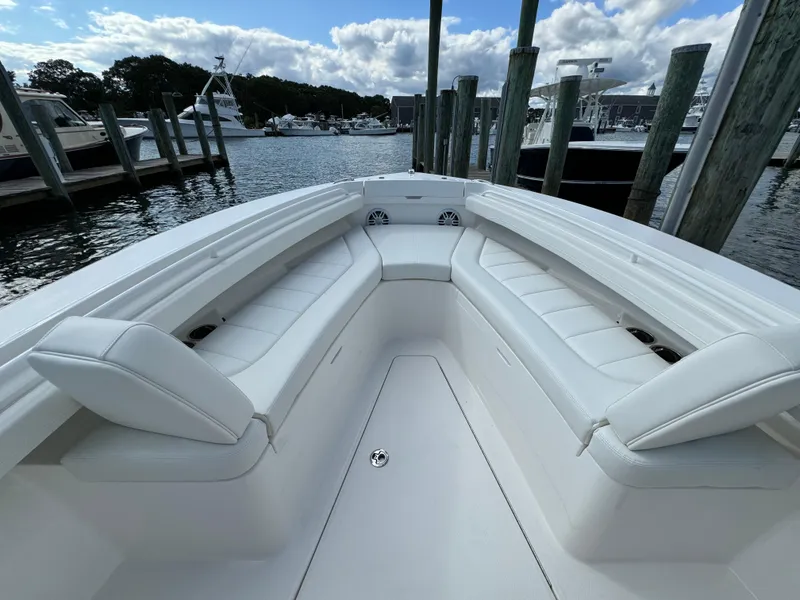 Slide: The Image of 2024 Regulator 23 boat with white seating, docked at a marina. - 40