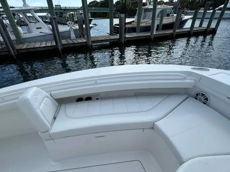 Slide: The Image of 2024 Regulator 23 boat with white seating, docked at a marina. - 42