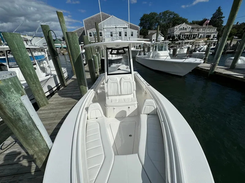 Slide: The Image of 2024 Regulator 23 boat docked at marina, showcasing sleek design and spacious seating. - 43