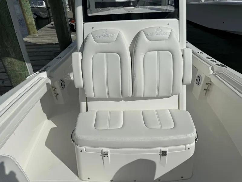 Slide: The Image of 2024 Regulator 23 boat with white cushioned seating and console. - 45
