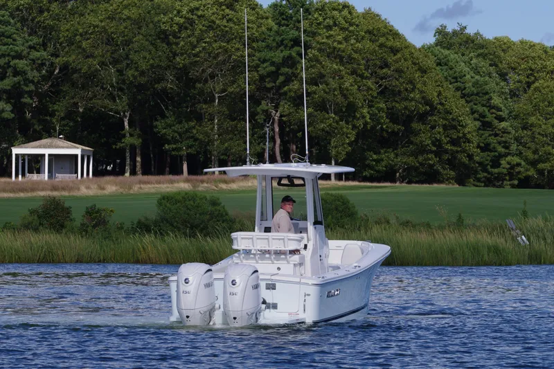 Slide: The Image of 2024 Regulator 23 boat cruising on a scenic lake with lush greenery. - 6