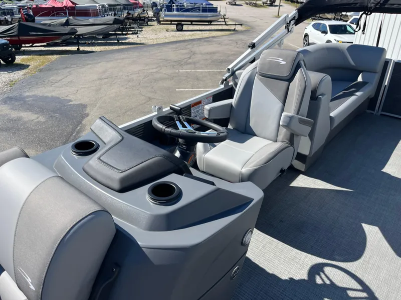 Slide: The Image of 2024 Bennington 22 SVSR pontoon boat interior with gray seating and steering console. - 11