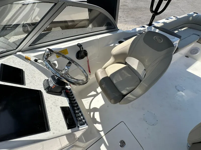 Slide: The Image of 2024 Key West 239 DFS boat interior with steering wheel and captain's chair. - 8