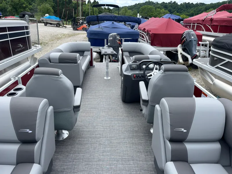 Slide: The Image of 2024 Bennington 22 SVSR pontoon boat with gray and white seating, docked at a marina. - 10