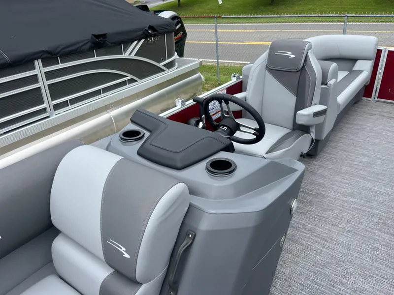 Slide: The Image of 2024 Bennington 22 SVSR pontoon boat interior with gray and white seating and steering console. - 6