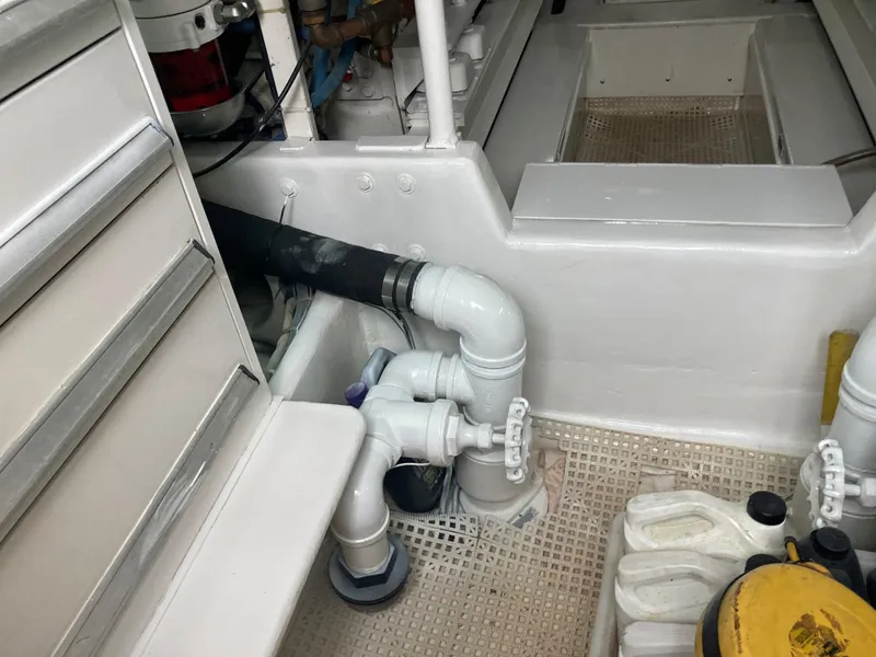 Slide: The Image of Engine room of 1999 Viking 55 Sport Fish boat, showing pipes and storage area. - 19