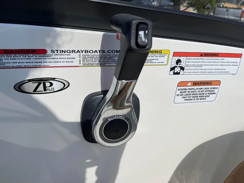 Slide: The Image of Throttle control of 2024 Stingray 201 DC boat with warning labels. - 10