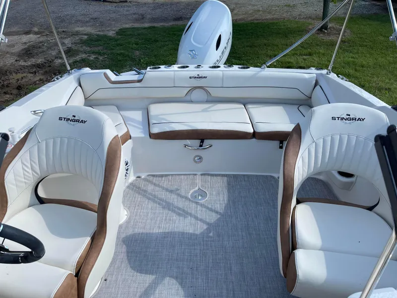 Slide: The Image of 2024 Stingray 201 DC boat interior with white and brown seating. - 17