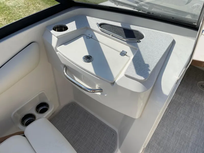 Slide: The Image of Interior view of 2024 Stingray 201 DC boat with storage compartment and cup holders. - 18