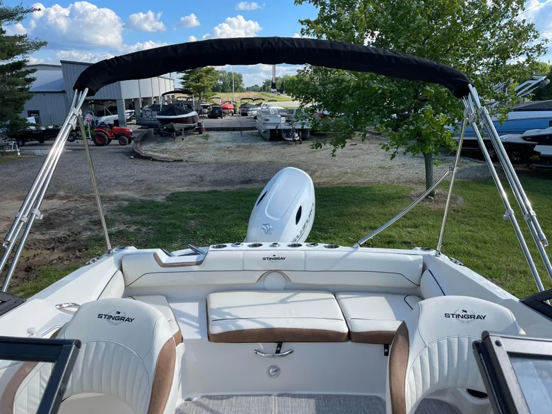 Slide: The Image of 2024 Stingray 201 DC boat with seating and outboard motor in a marina. - 3