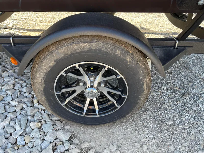 Slide: The Image of 2024 G3 Sportsman 1710 PFX trailer wheel on gravel surface. - 12