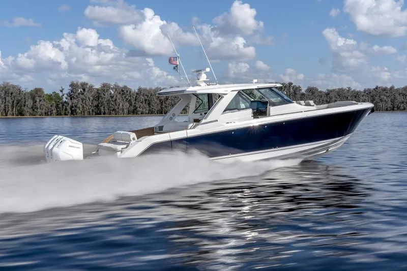 Slide: The Image of 2023 Tiara Yachts 48 LS cruising on a lake under a blue sky. - 12