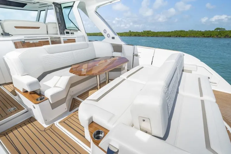 Slide: The Image of 2023 Tiara Yachts 48 LS luxury yacht with white seating and wooden table on deck. - 18