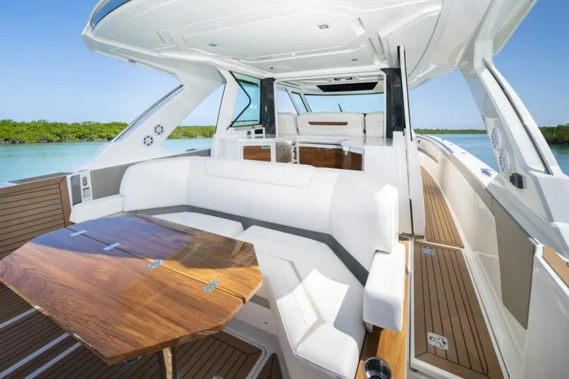 Slide: The Image of 2023 Tiara Yachts 48 LS luxury boat interior with white seating and wooden table. - 25