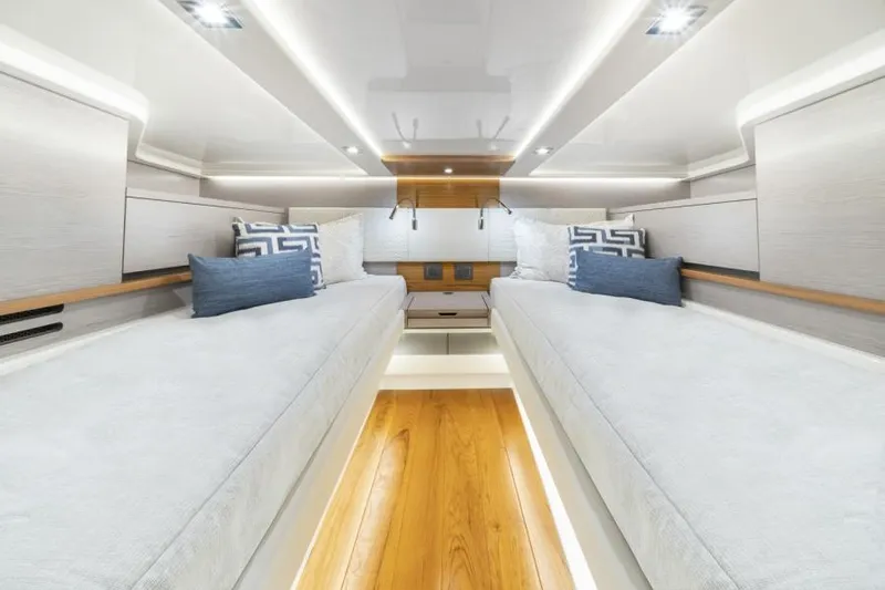 Slide: The Image of 2023 Tiara Yachts 48 LS cabin interior with twin beds and modern lighting. - 34