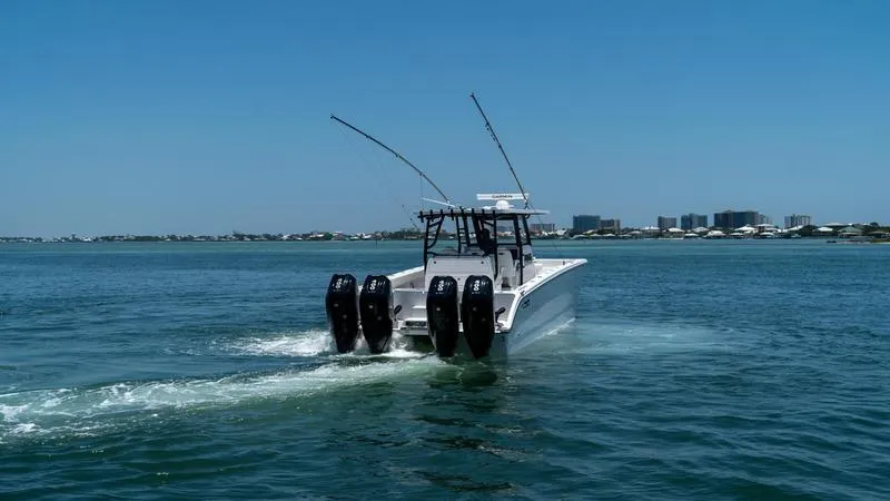 Slide: The Image of 2024 Invincible 40' Catamaran cruising on open water with city skyline in background. - 10