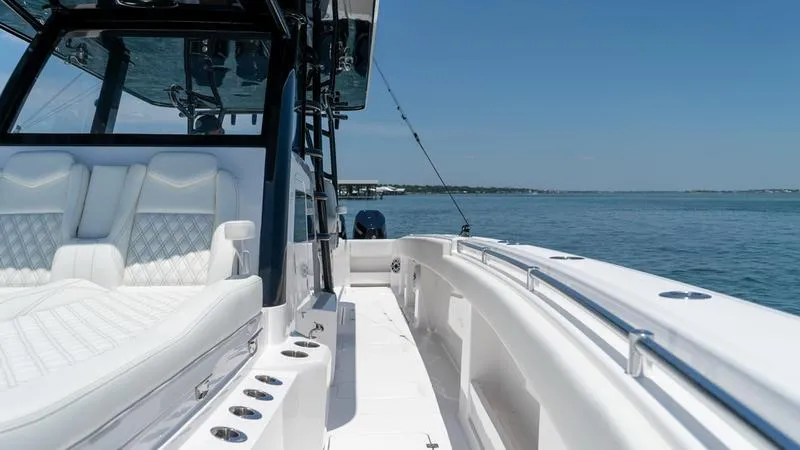 Slide: The Image of 2024 Invincible 40' Catamaran with luxurious white seating on calm waters. - 17