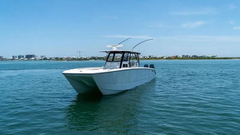 Slide: The Image of 2024 Invincible 40' Catamaran on calm waters with a clear blue sky. - 2