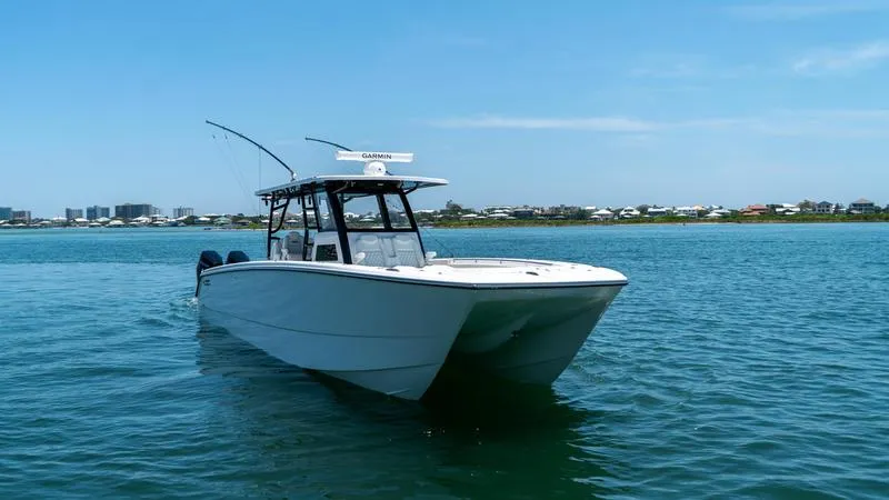 Slide: The Image of 2024 Invincible 40' Catamaran on calm waters with coastal background. - 4