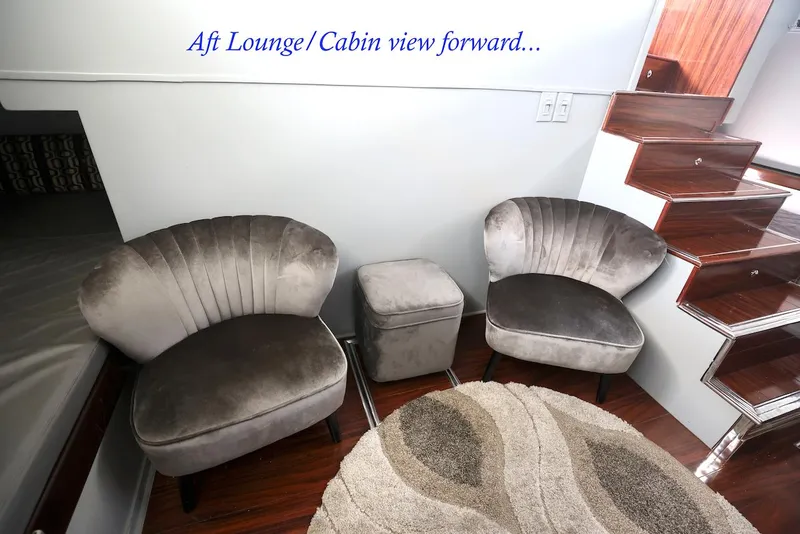 Slide: The Image of Elegant yacht lounge area with gray chairs, carpet, and staircase. - 40