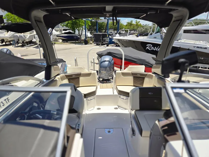 Slide: The Image of 2021 Chaparral 230 boat interior with seating and outboard motor. - 7