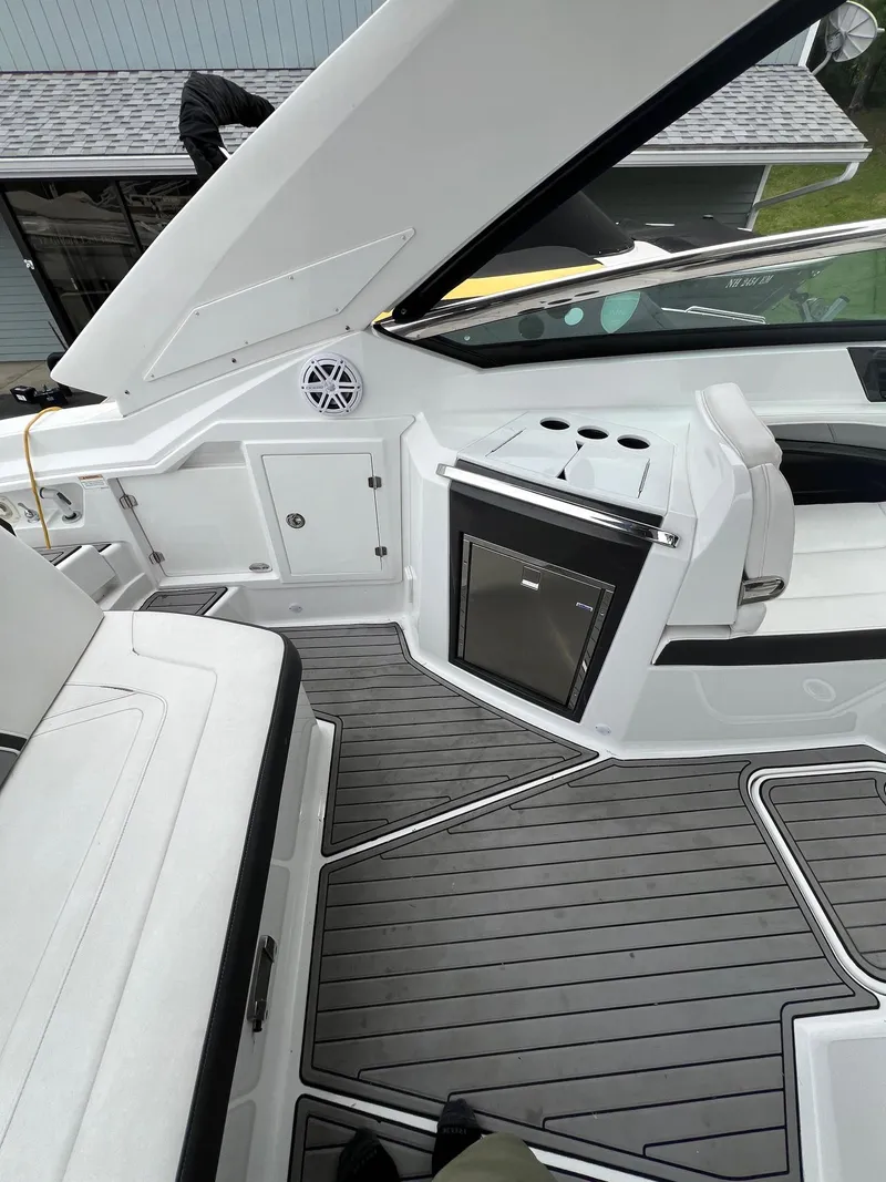 Slide: The Image of 2016 Monterey 328SS boat interior with seating, storage, and a mini-fridge. - 15