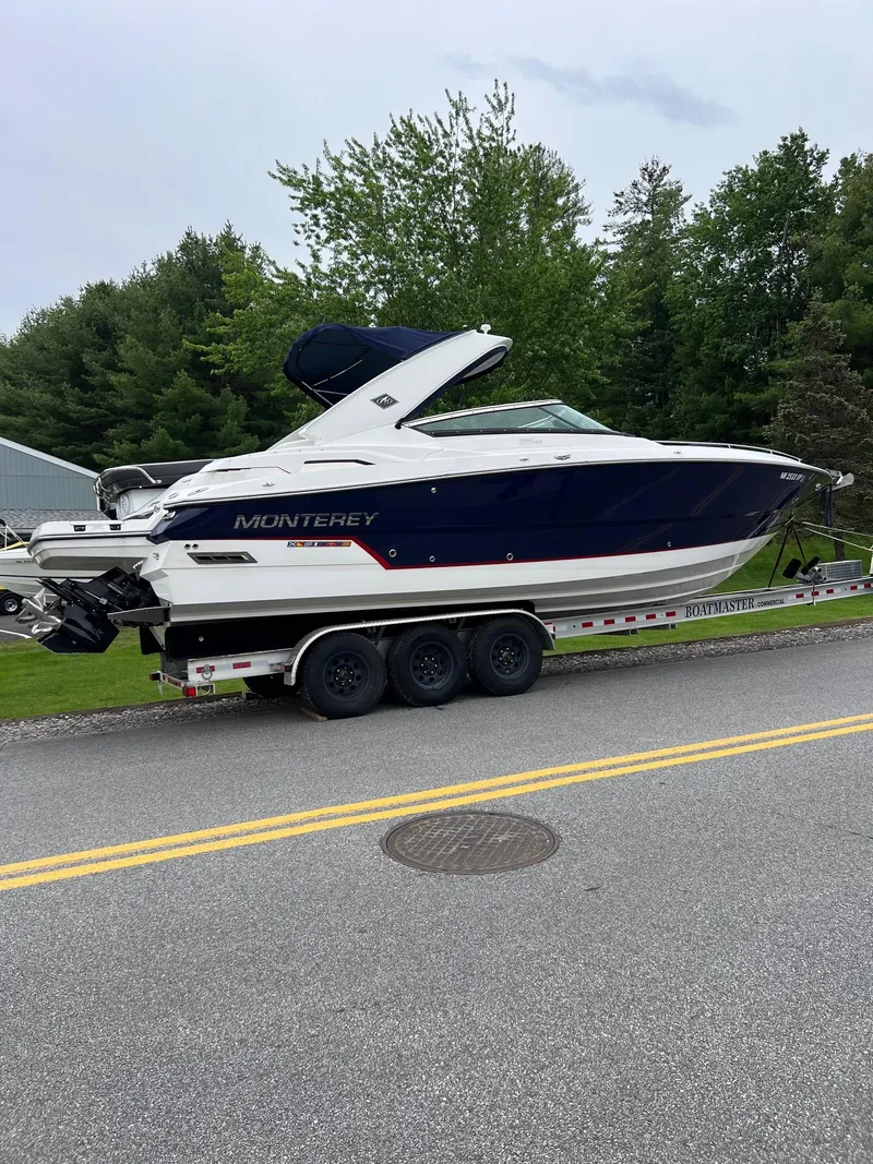 Slide: The Image of 2016 Monterey 328SS boat on a trailer, parked on a road with trees in the background. - 22