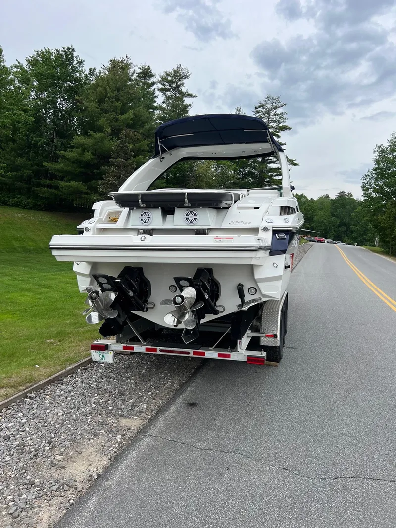 Slide: The Image of 2016 Monterey 328SS boat on trailer, parked roadside with lush greenery. - 23