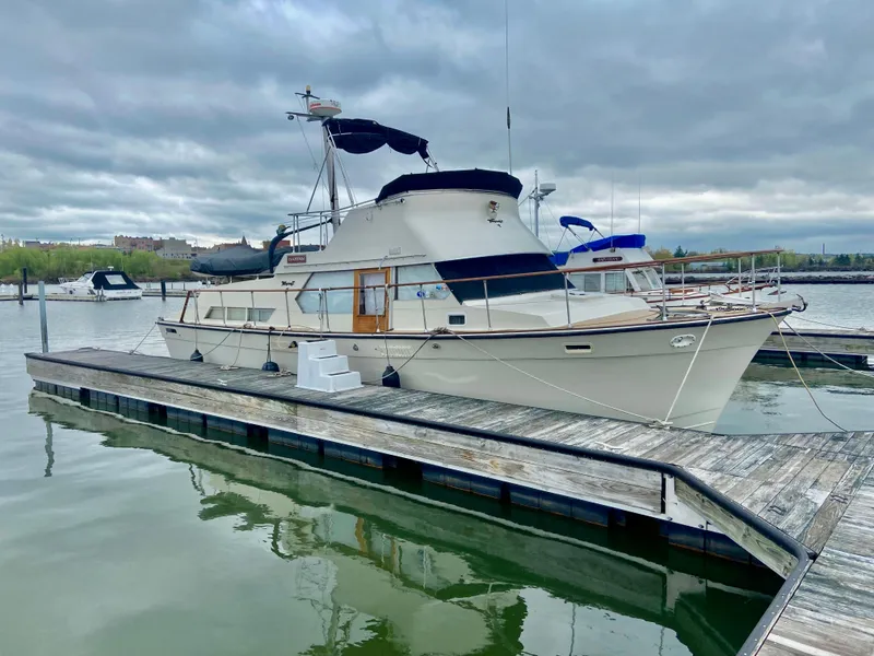 The Image of 1974 Tollycraft 40 Tri-Cabin Motoryacht docked at marina under cloudy sky. - 0