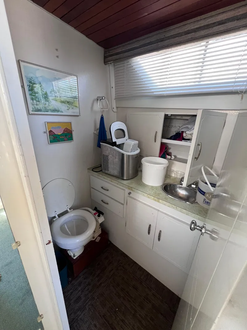 Slide: The Image of 1974 Tollycraft 40 Tri-Cabin Motoryacht bathroom with sink, toilet, and storage cabinets. - 10