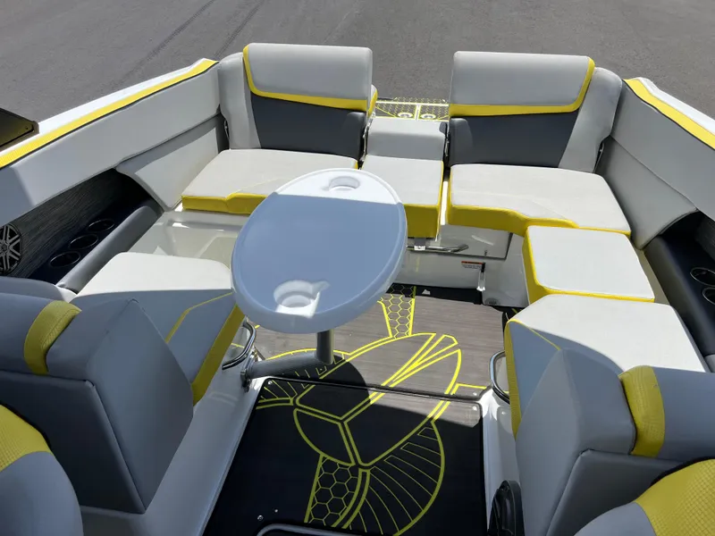 Slide: The Image of 2023 Scarab 255 Wake ID boat interior with yellow-accented seating and oval table. - 14