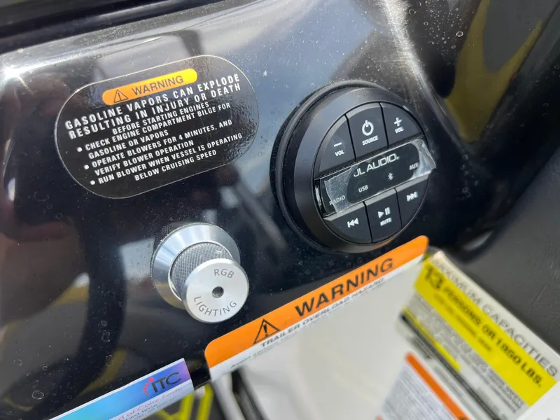 Slide: The Image of Control panel of 2023 Scarab 255 Wake ID with warning labels and audio controls. - 23