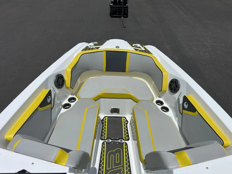 Slide: The Image of 2023 Scarab 255 Wake ID boat interior with yellow and gray seating, cup holders, and speakers. - 30