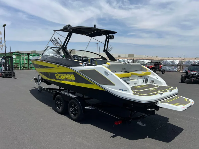 Slide: The Image of 2023 Scarab 255 Wake ID boat with yellow accents on a trailer in a parking lot. - 4