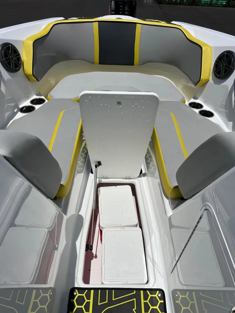 Slide: The Image of 2023 Scarab 255 Wake ID boat interior with gray and yellow seating, storage compartments, and speakers. - 42