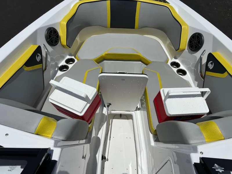 Slide: The Image of 2023 Scarab 255 Wake ID boat interior with yellow and gray seating, cup holders, and speakers. - 43
